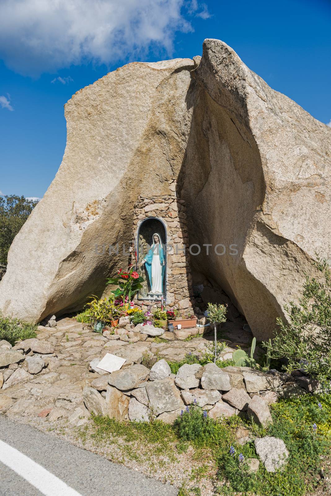 religious monument with the catholic statute of maria along the road on the italian island of sardinia