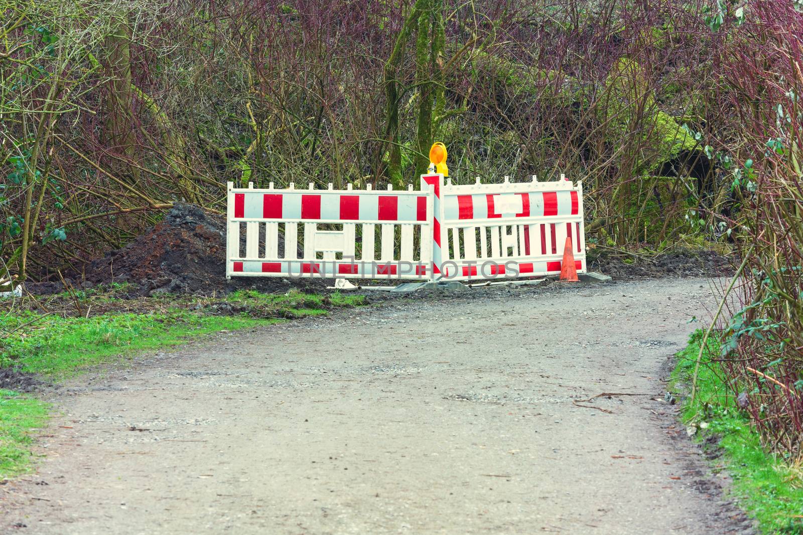 Red whitepolice line with yellow lettering for crime scene investigation in a rural area in the forest.