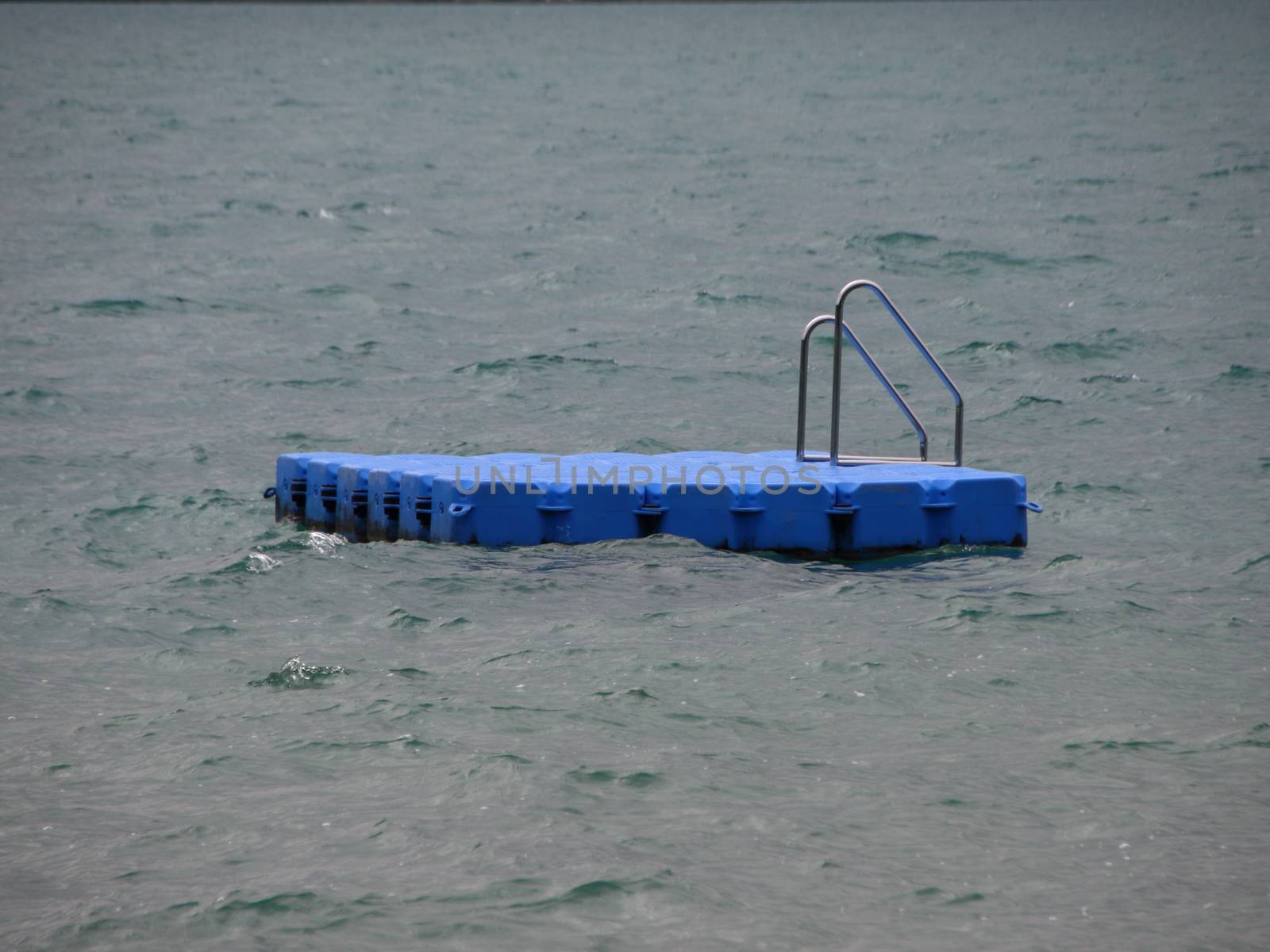 Isolated Blue Ponton Swimming Platform on Stormy Cold Water