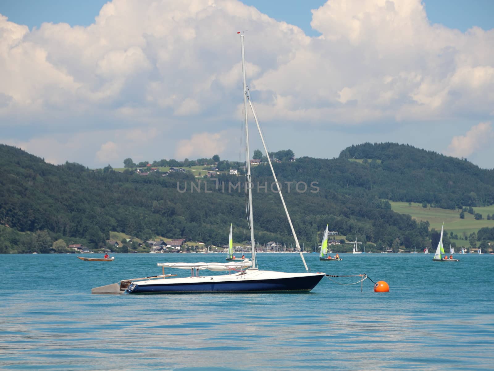 Sailing Ship on Blue Water with Mountain Forest in Background