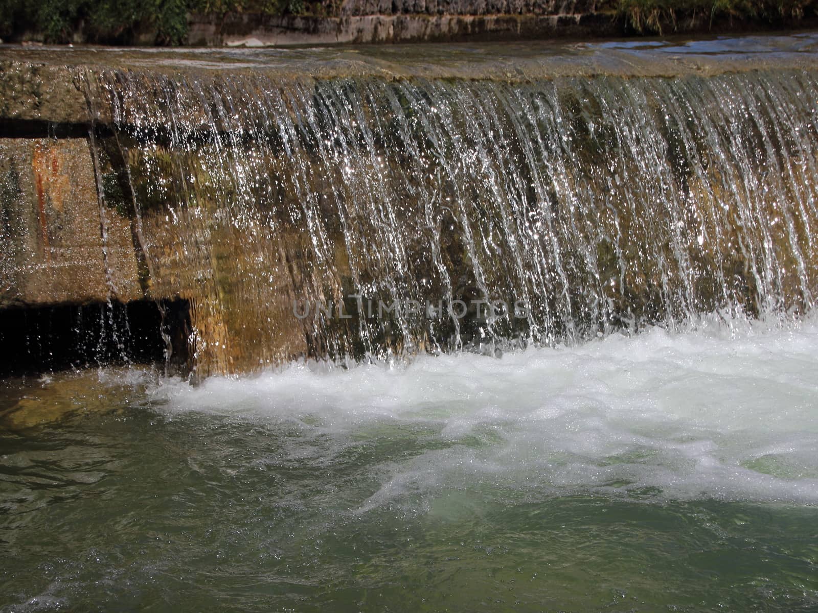 Waterfall in Drain Canal with Melting Water from Mountains