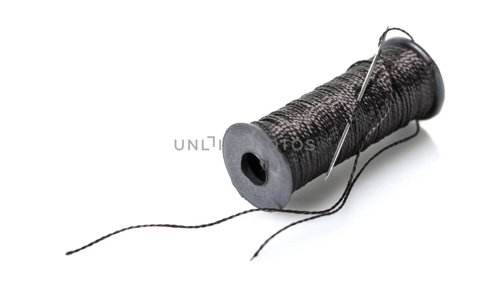 spool of black thread on white isolated background