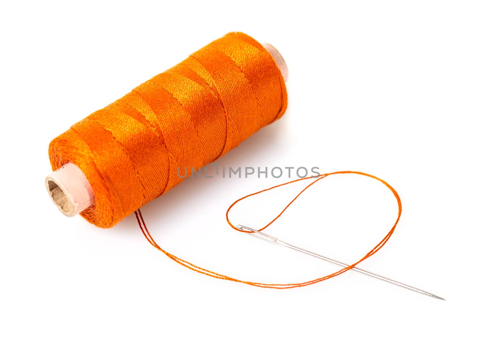 spool of thread with a needle on white isolated background