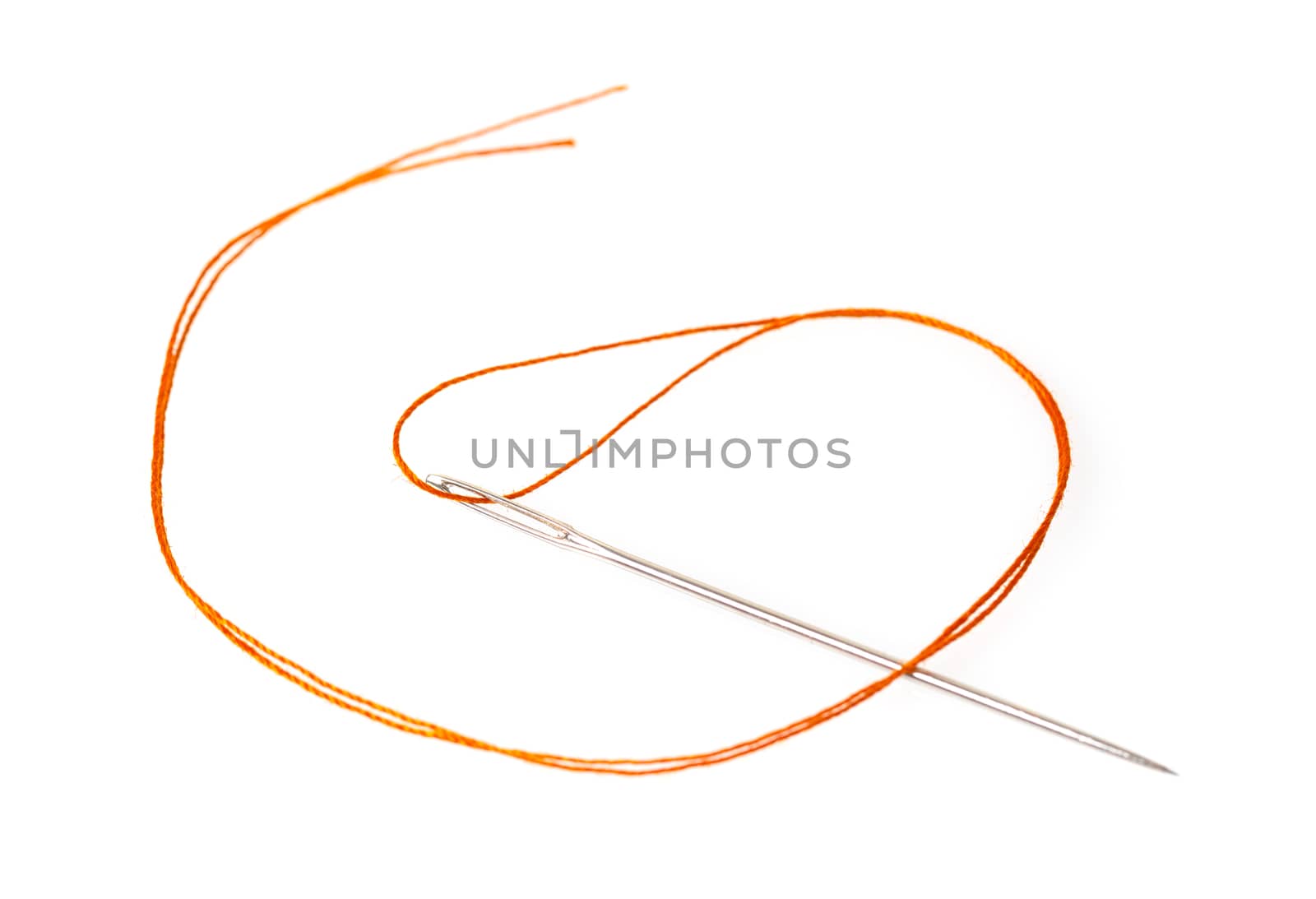 orange thread in a needle on a white isolated background