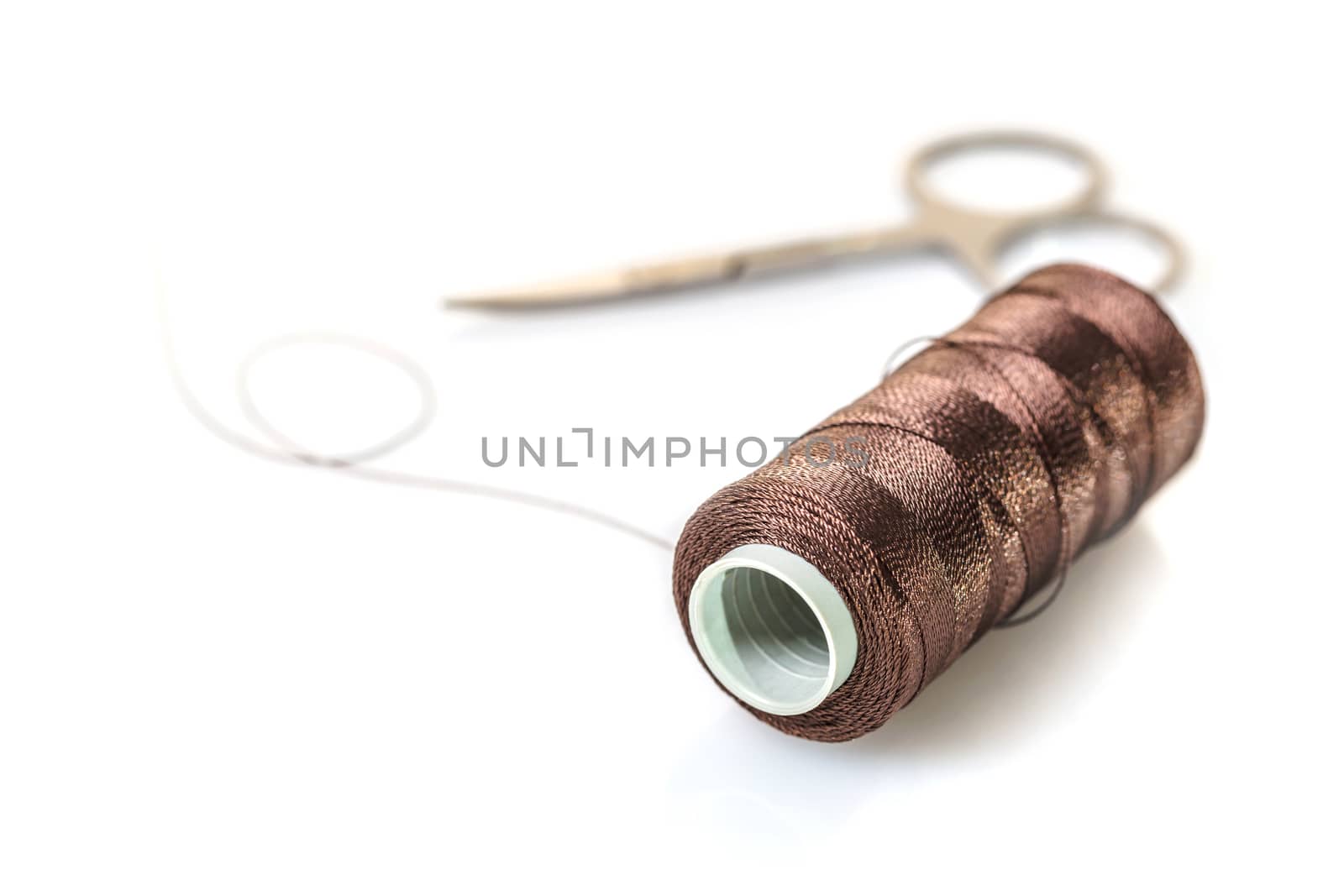 spool of brown threads on a white background