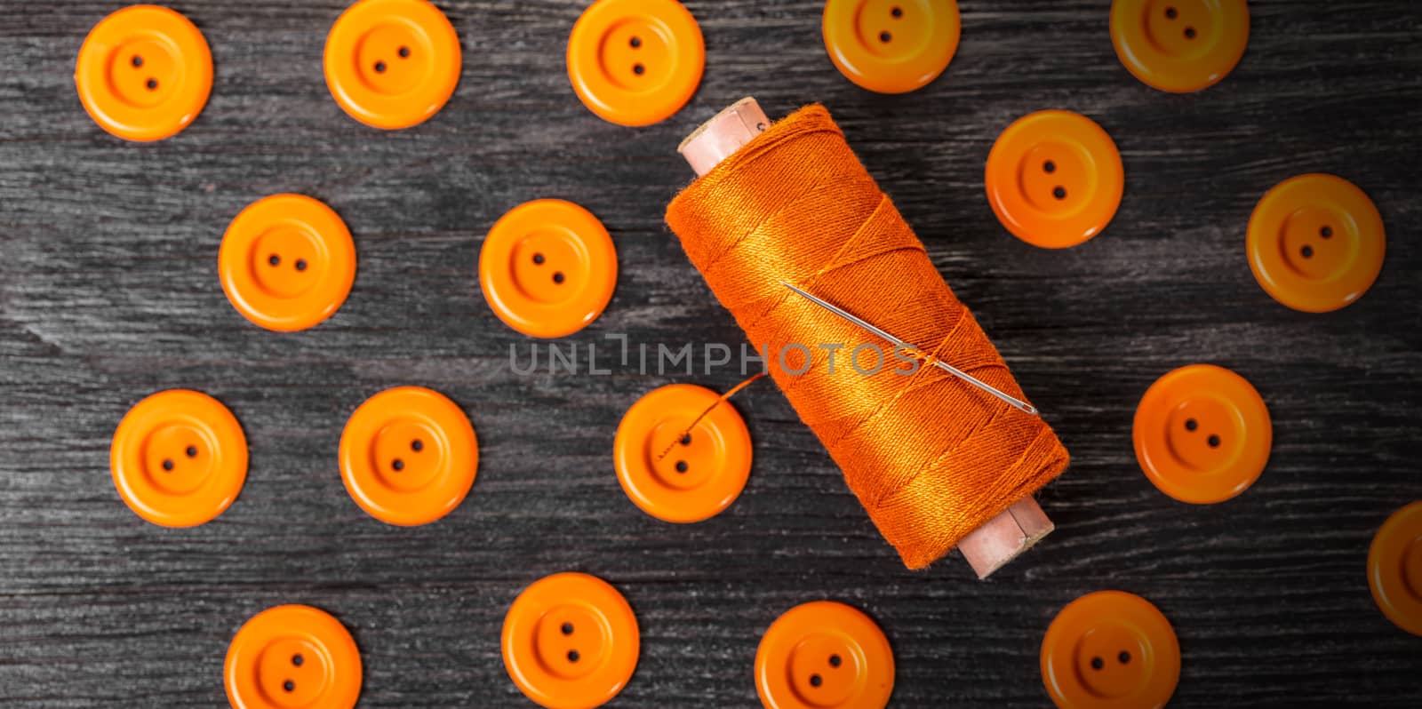 spool of threads and buttons on a wooden background