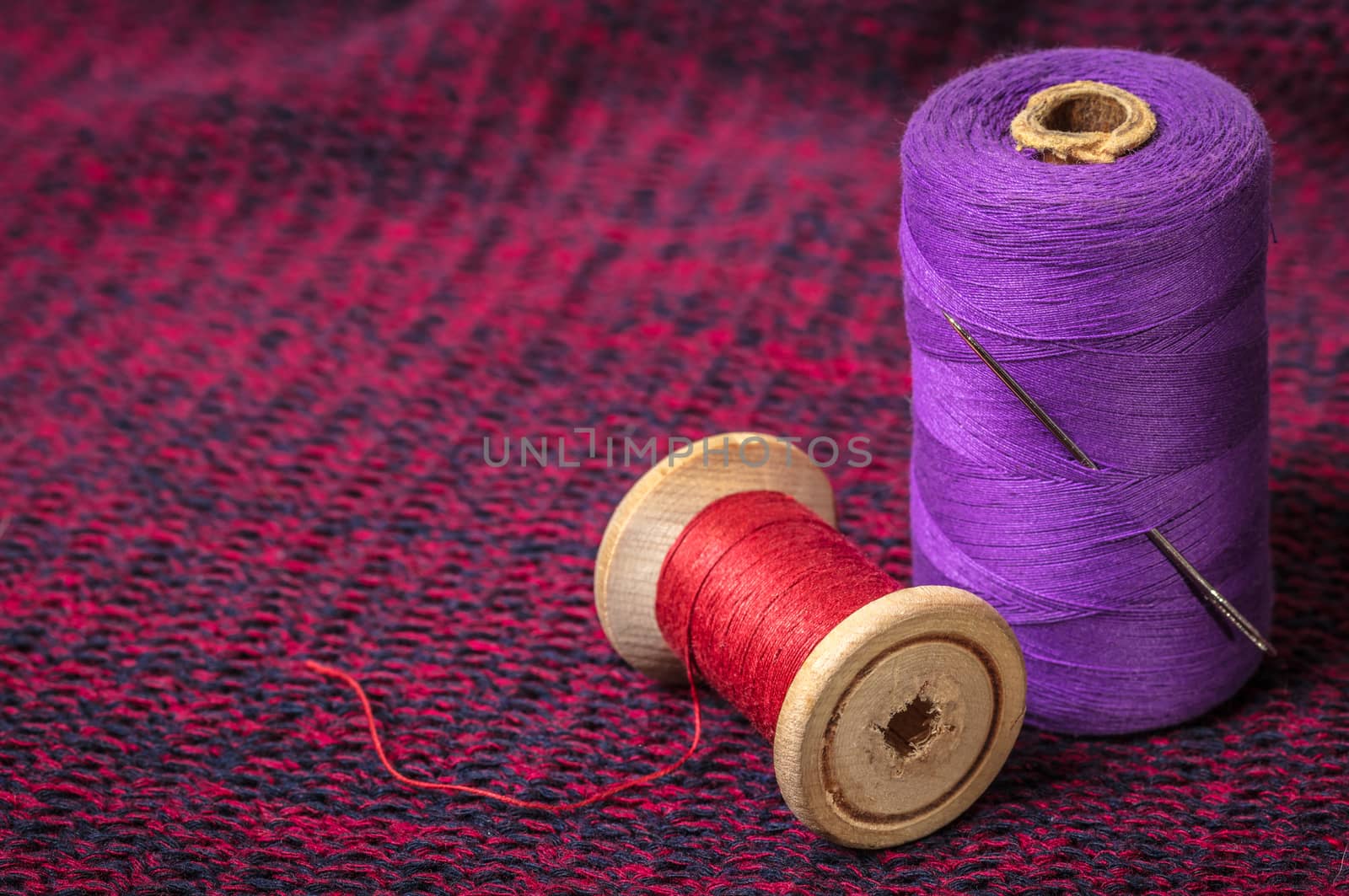 spools of colored threads against the background of knitted fabric