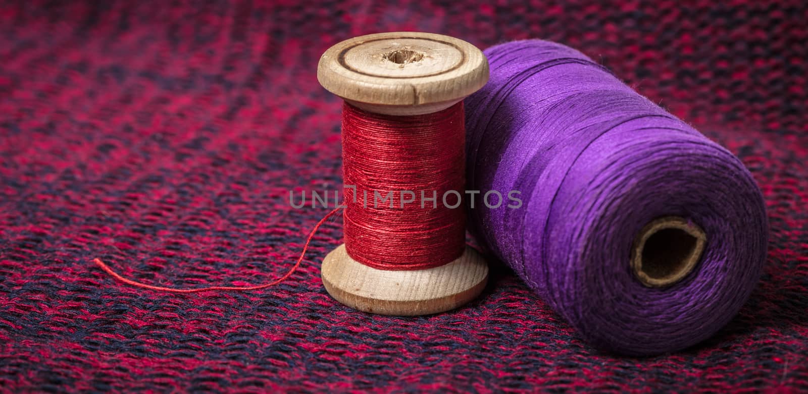 spools of colored threads against the background of knitted fabric