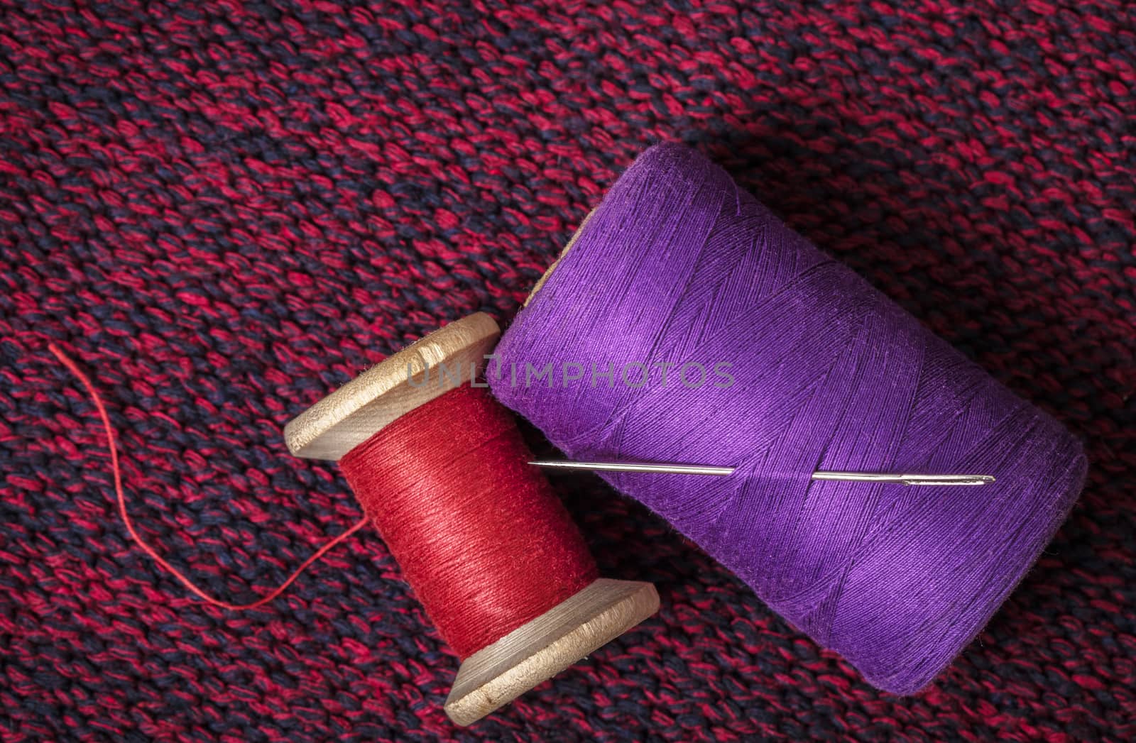 spools of colored threads against the background of knitted fabric