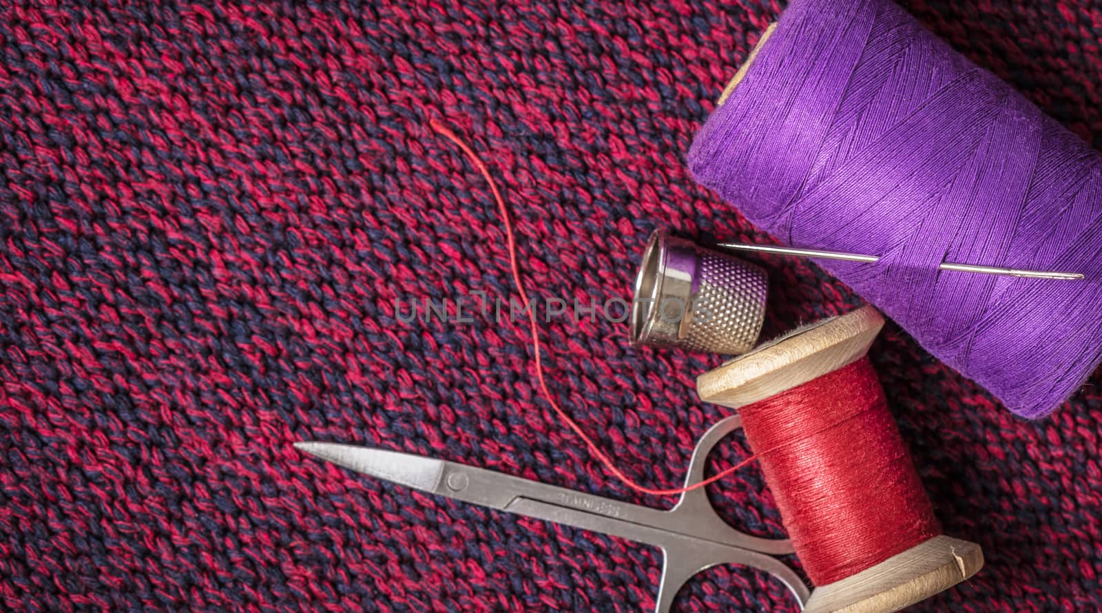 spools of colored threads against the background of knitted fabric