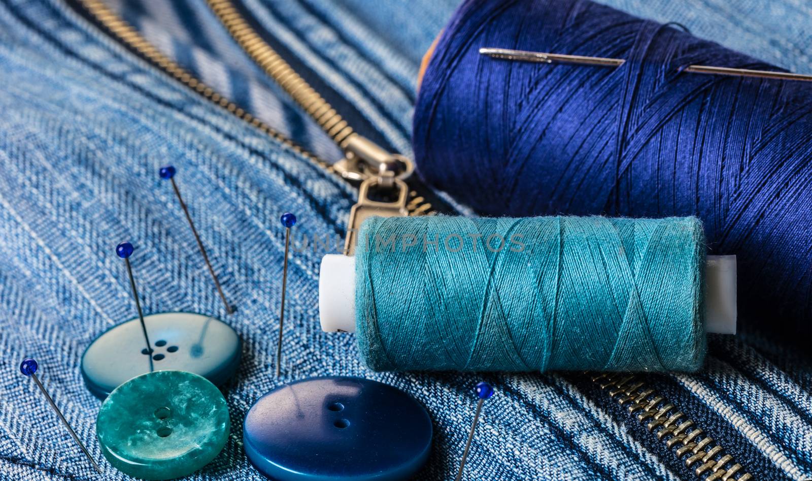 blue threads with buttons on the background of a denim jacket