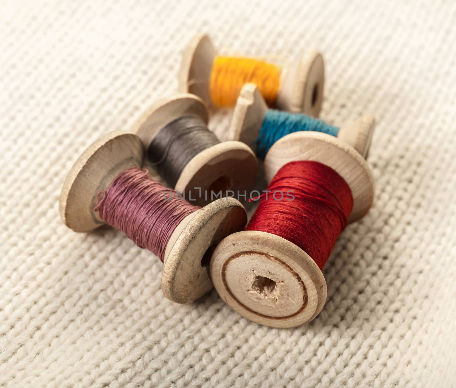 coils of colored thread on white knitted fabric