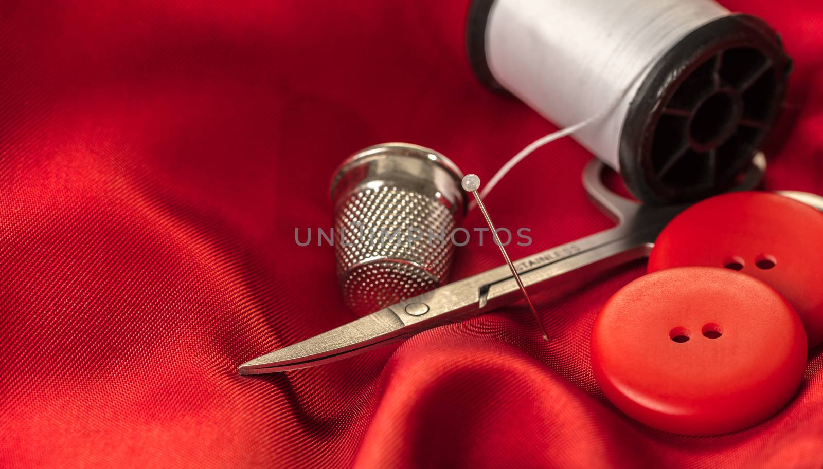 sewing accessories on a background of red fabric