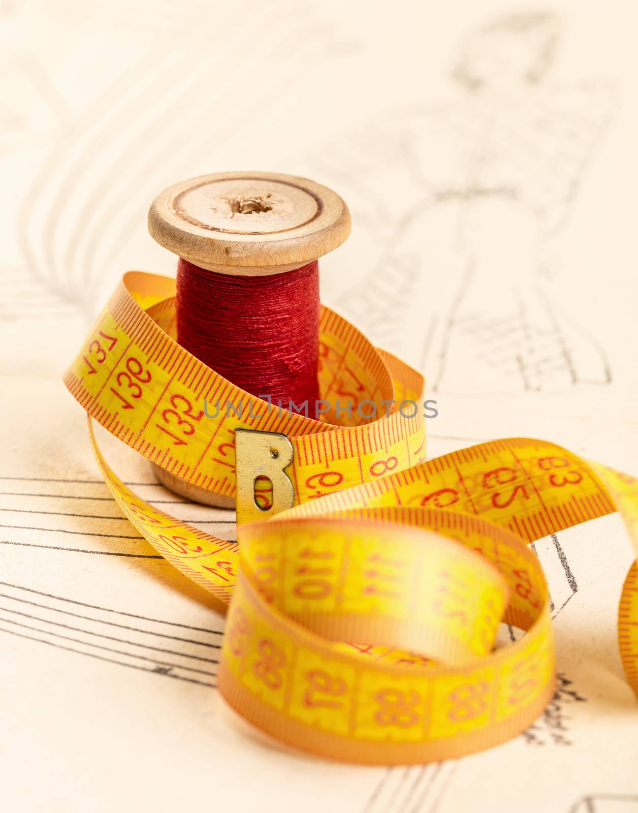 red thread and meter on background of paper pattern