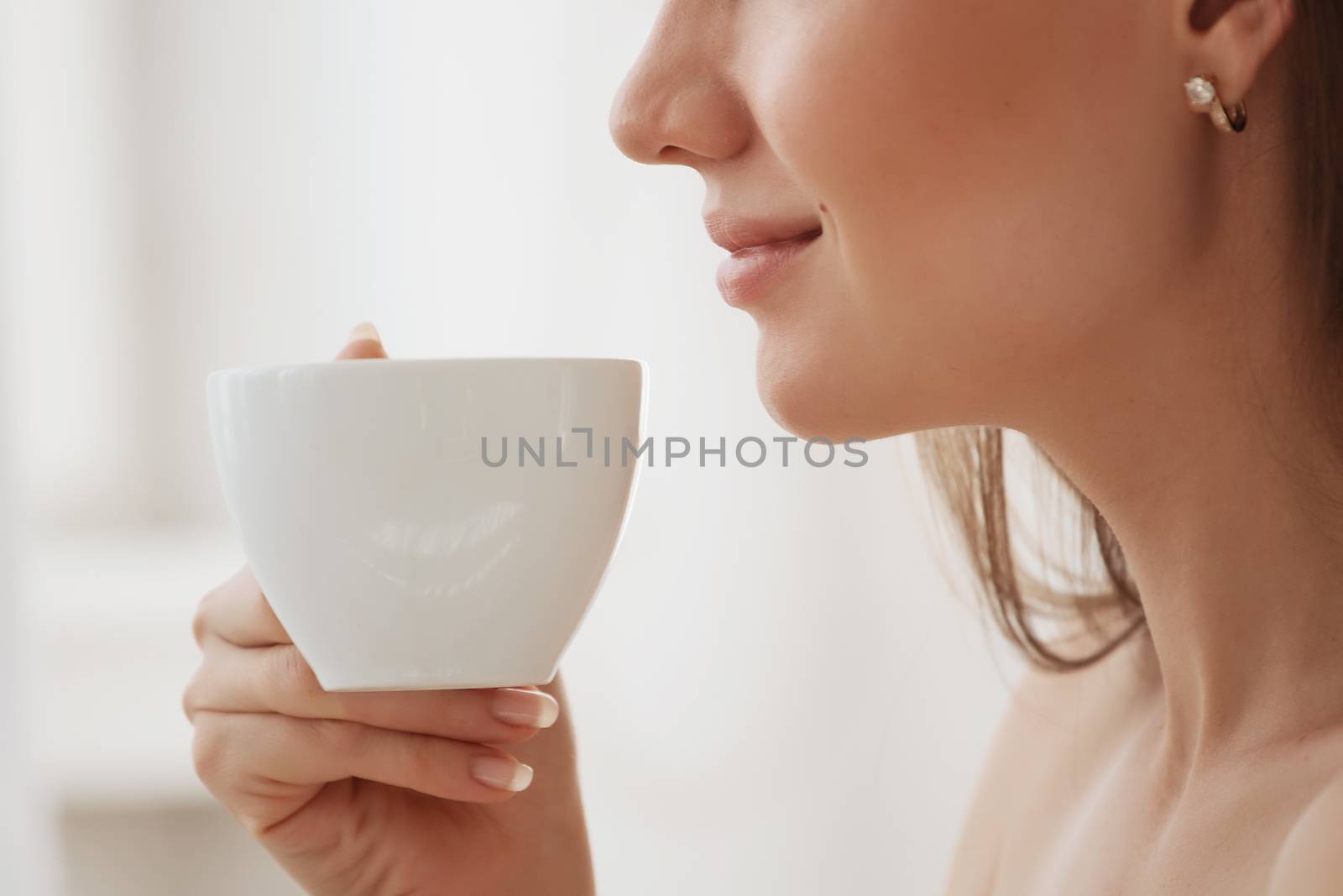 Close up of a girl with a mug in her hands.