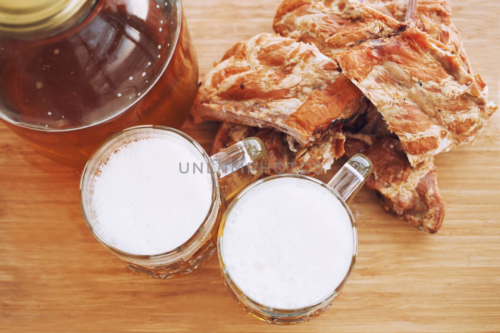 Barbecue pork ribs with beer. On wooden background.