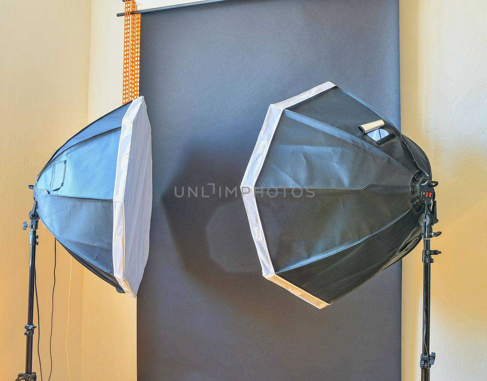 Empty photo studio with lighting equipment. Black background in photo studio.