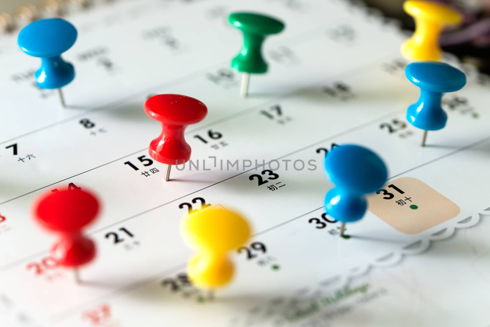 Thumb tack pins on calendar as reminder by Kenishirotie