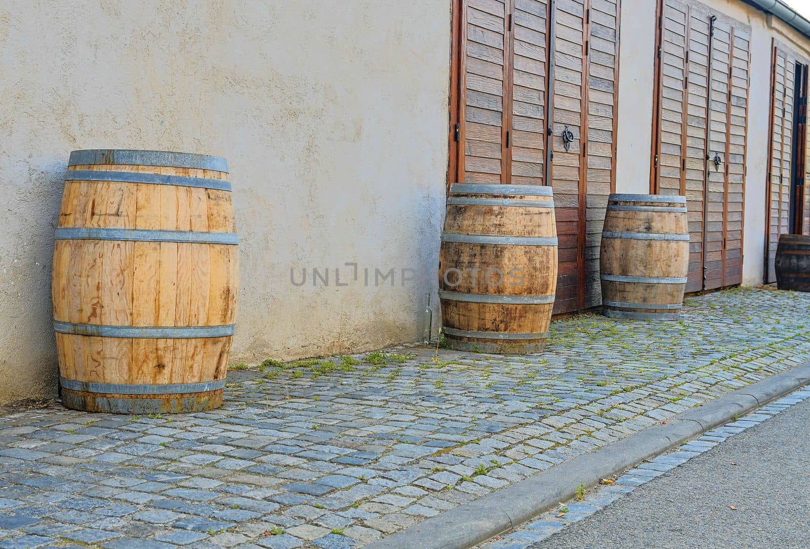 Old rustic wine barrels in front of modern wine cellar. Wine background in Europe. Czech Republic, South Moravia. 