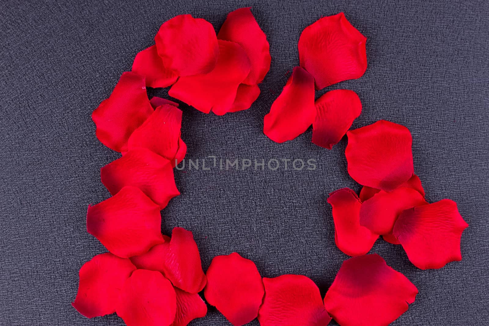 Artificial petals red roses black background frame