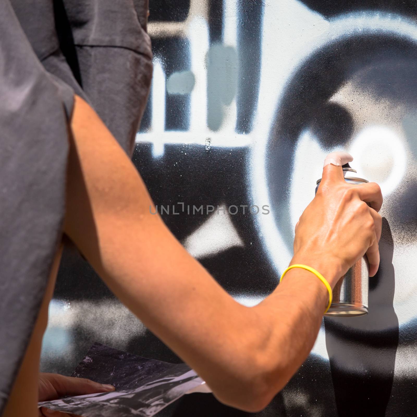 TURIN, ITALY - June 07, 2018: anonymous graffiti artist working on his piece of street art in urban area