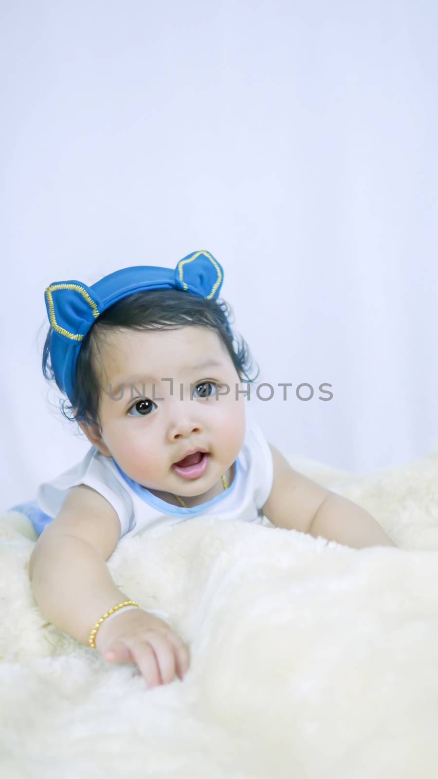 Asian Smiling baby girl crawling in bedroom