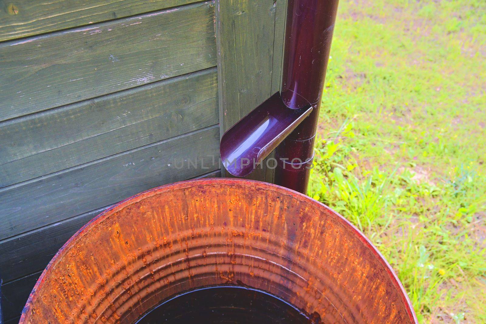 Old iron barrel and plastical gutter ready for summer rains by roman_nerud