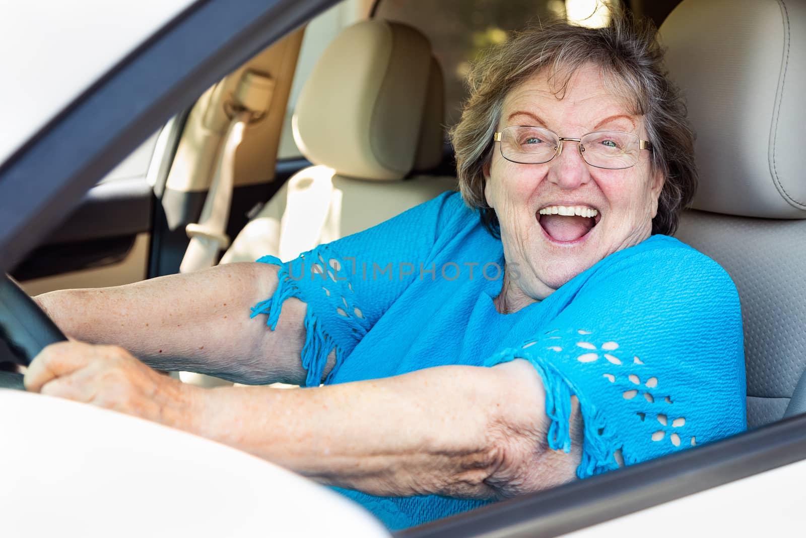 Happy Senior Woman Driving New Car by Feverpitched