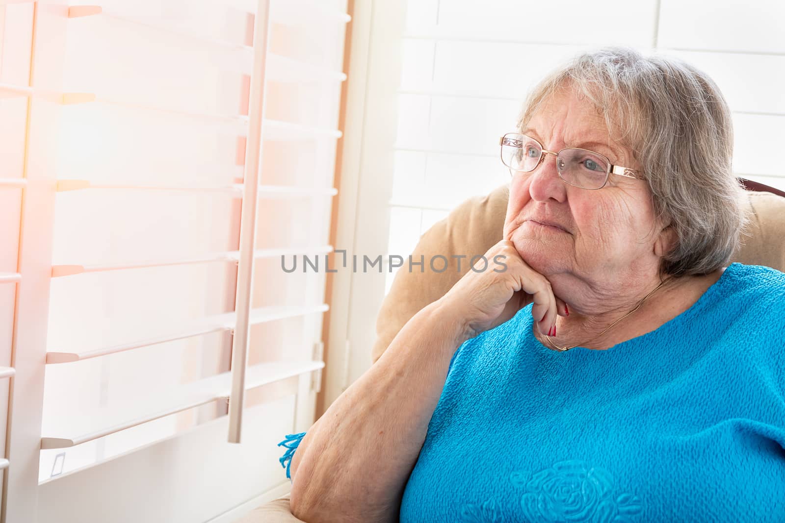 Contemplative Senior Woman Gazing Out of Her Window by Feverpitched