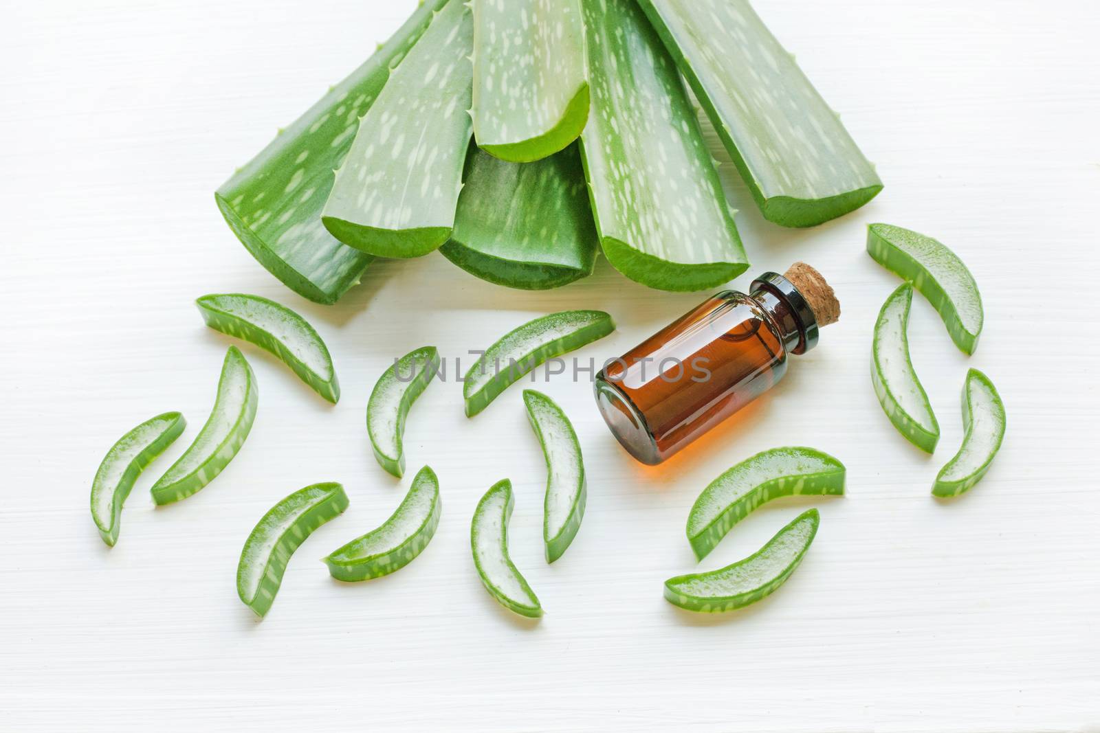 Aloe Vera leaf with bottle of aloe vera essential oil isolated on white background.