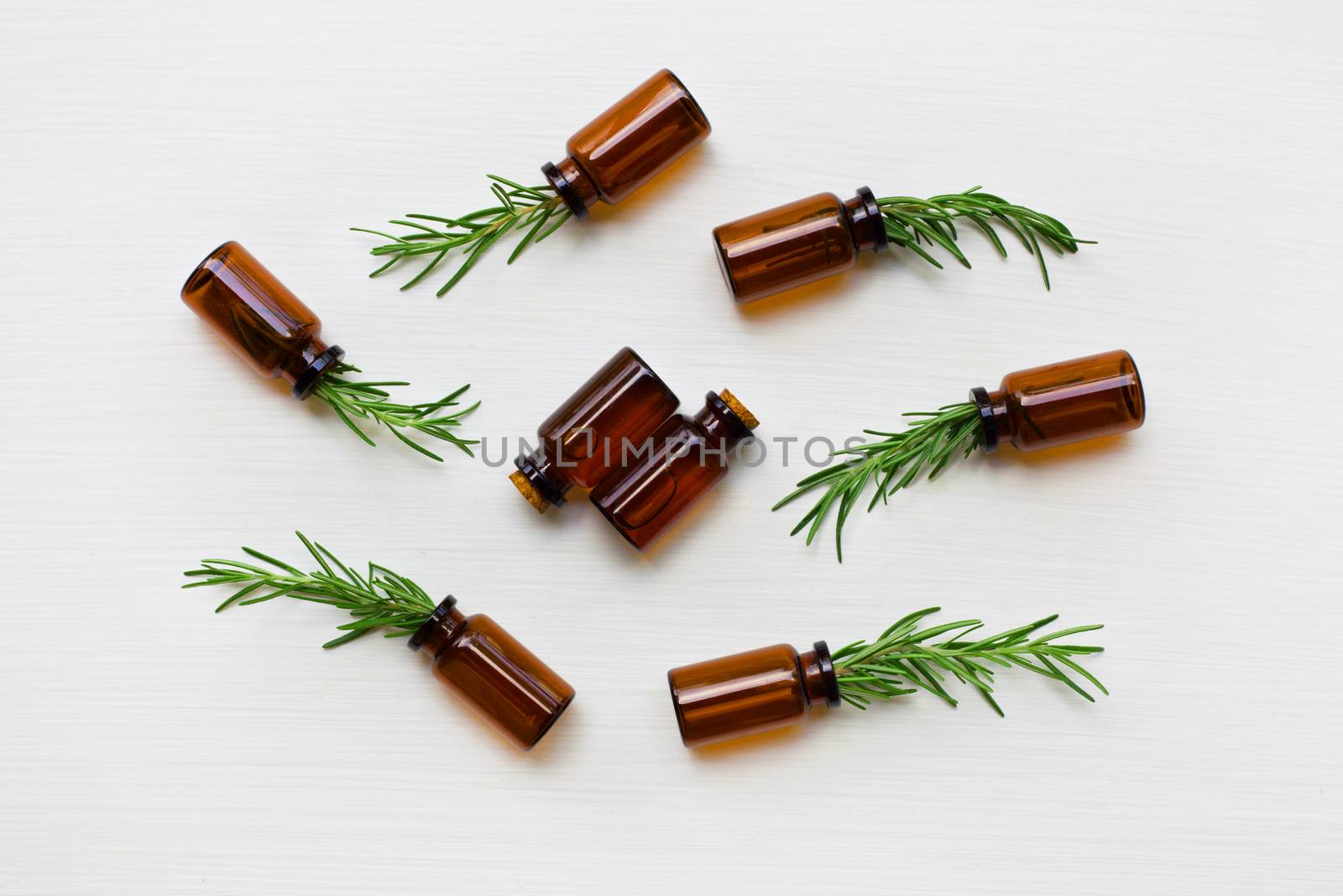 Glass bottle of essential oil  with rosemary. Top view