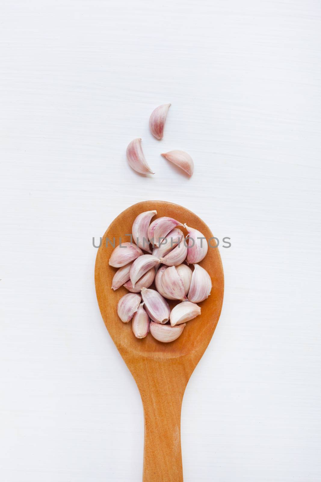 Garlic on white wooden background.