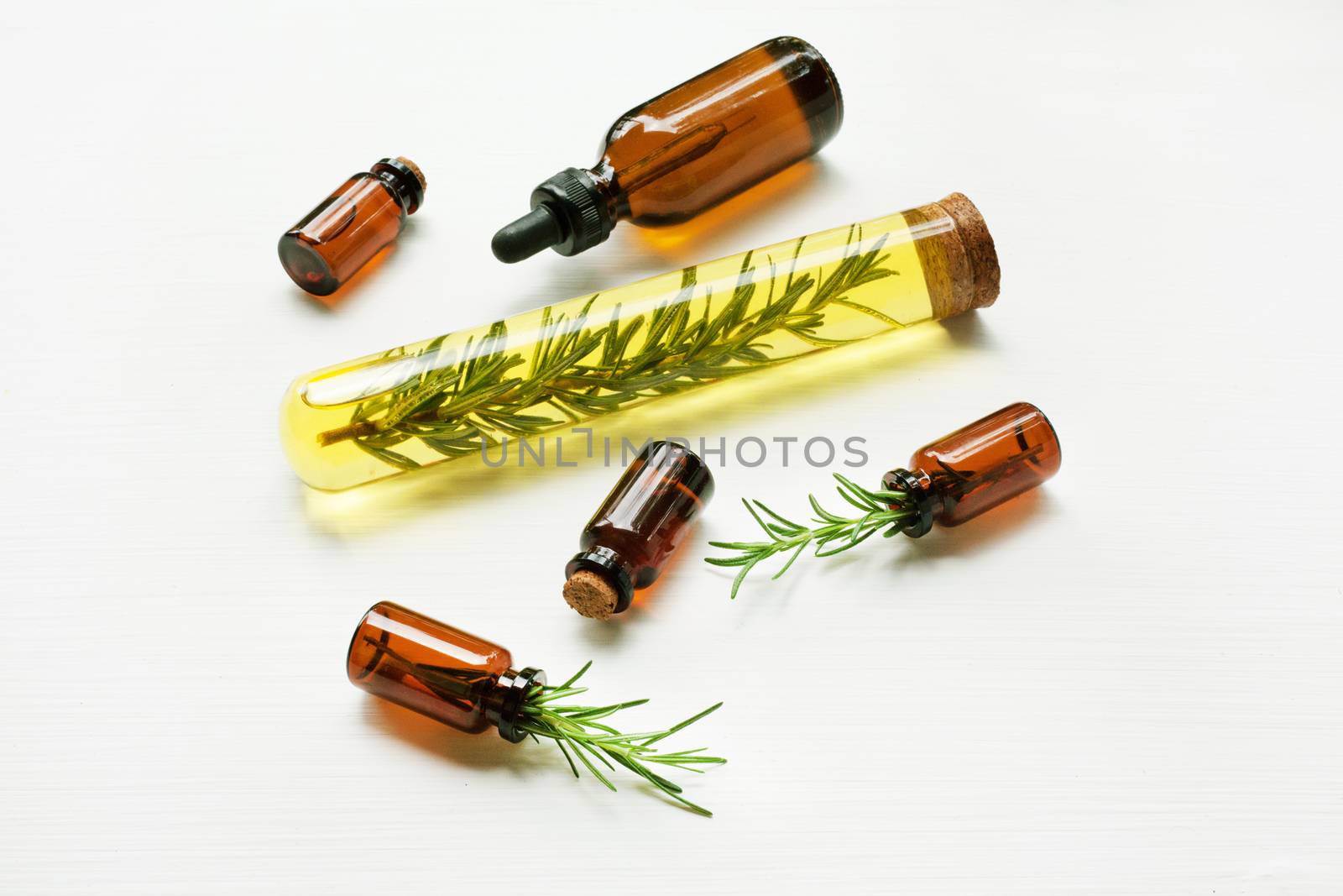 Glass bottle of essential oil  with rosemary. Top view