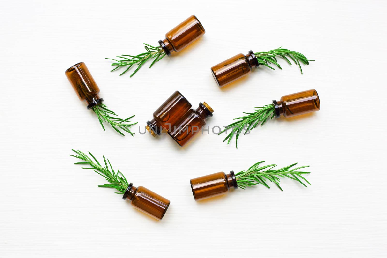 Glass bottle of essential oil  with rosemary. Top view