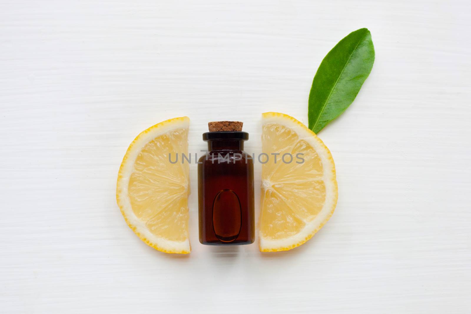 Fresh lemon with lemon essential oil on a white background.