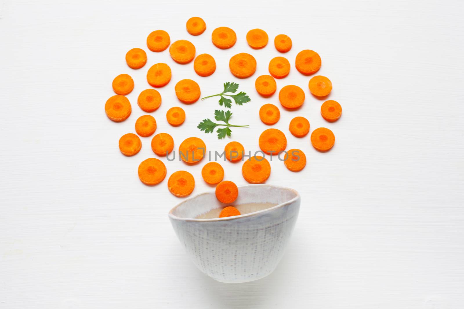 Chopped carrot slices and parsley leaves  isolated on white background.