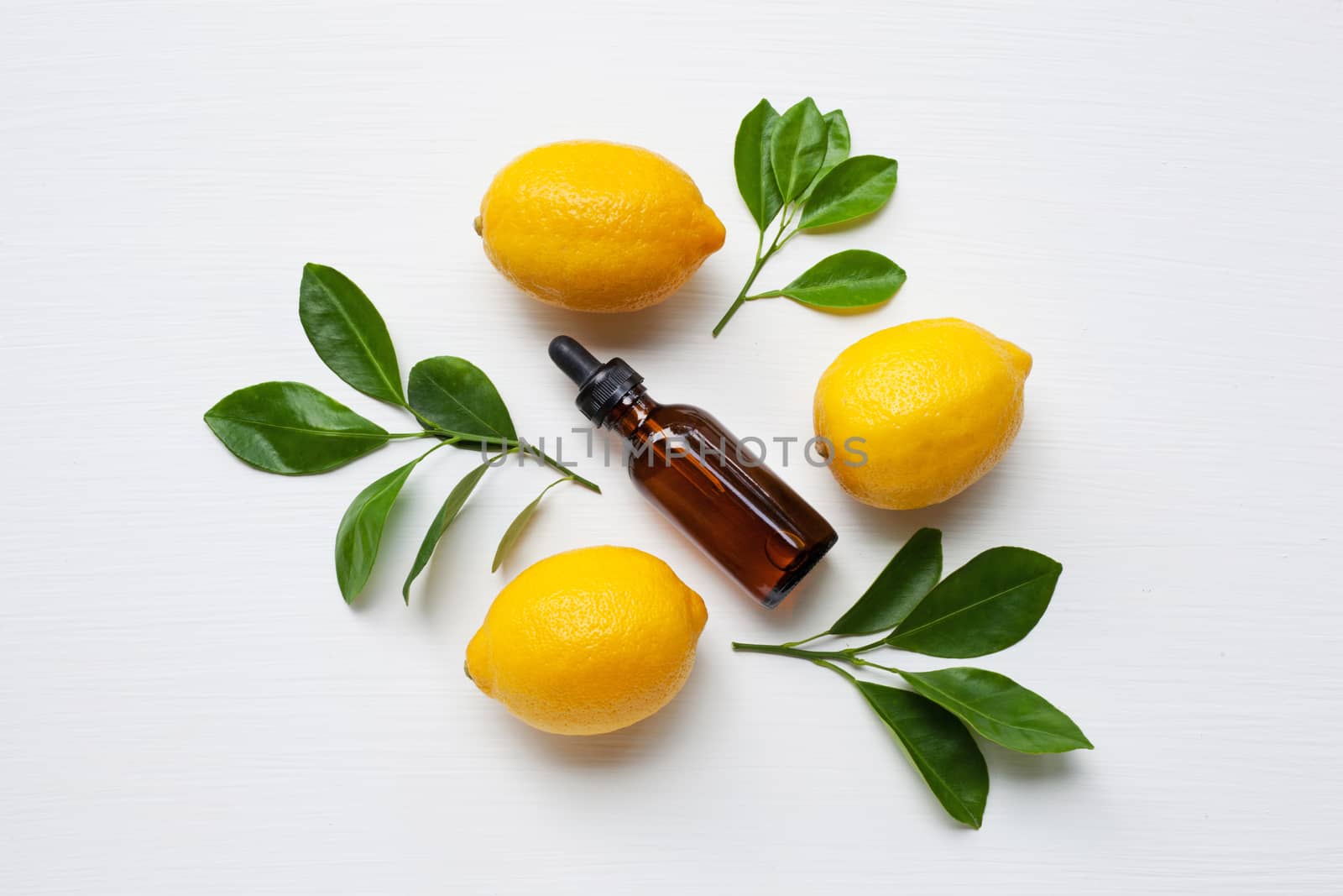 Fresh lemon with lemon essential oil on a white background.