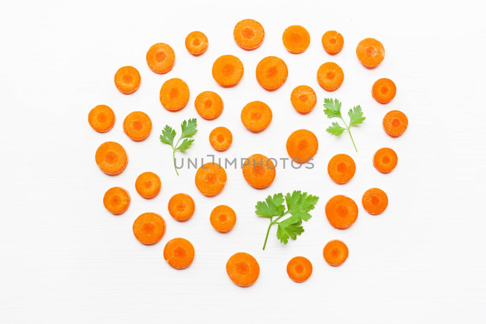 Chopped carrot slices and parsley leaves  isolated on white background.