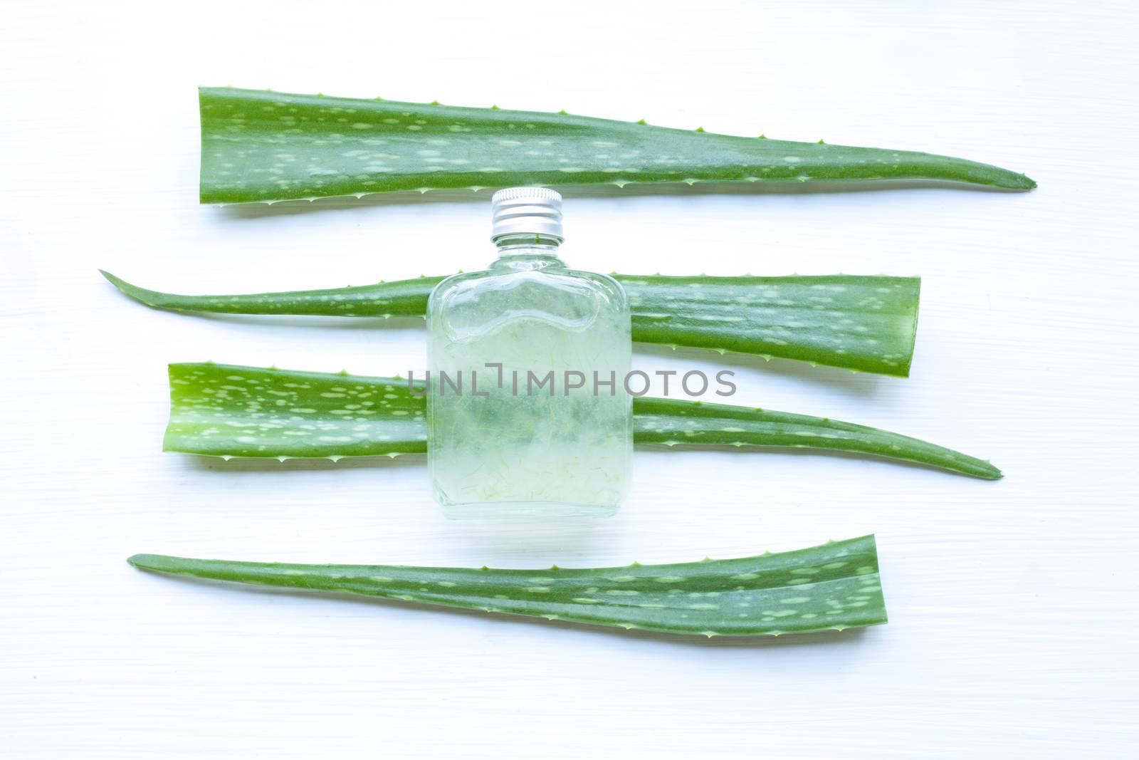 Aloe Vera leaf with bottle of aloe vera juice on white background.