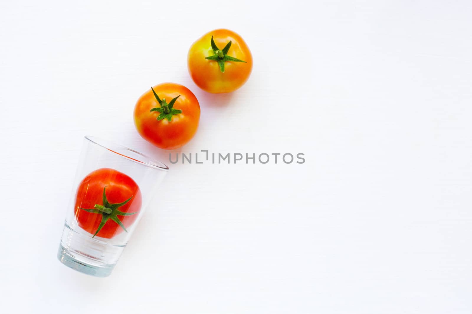Tomatoes with glass on a white background.