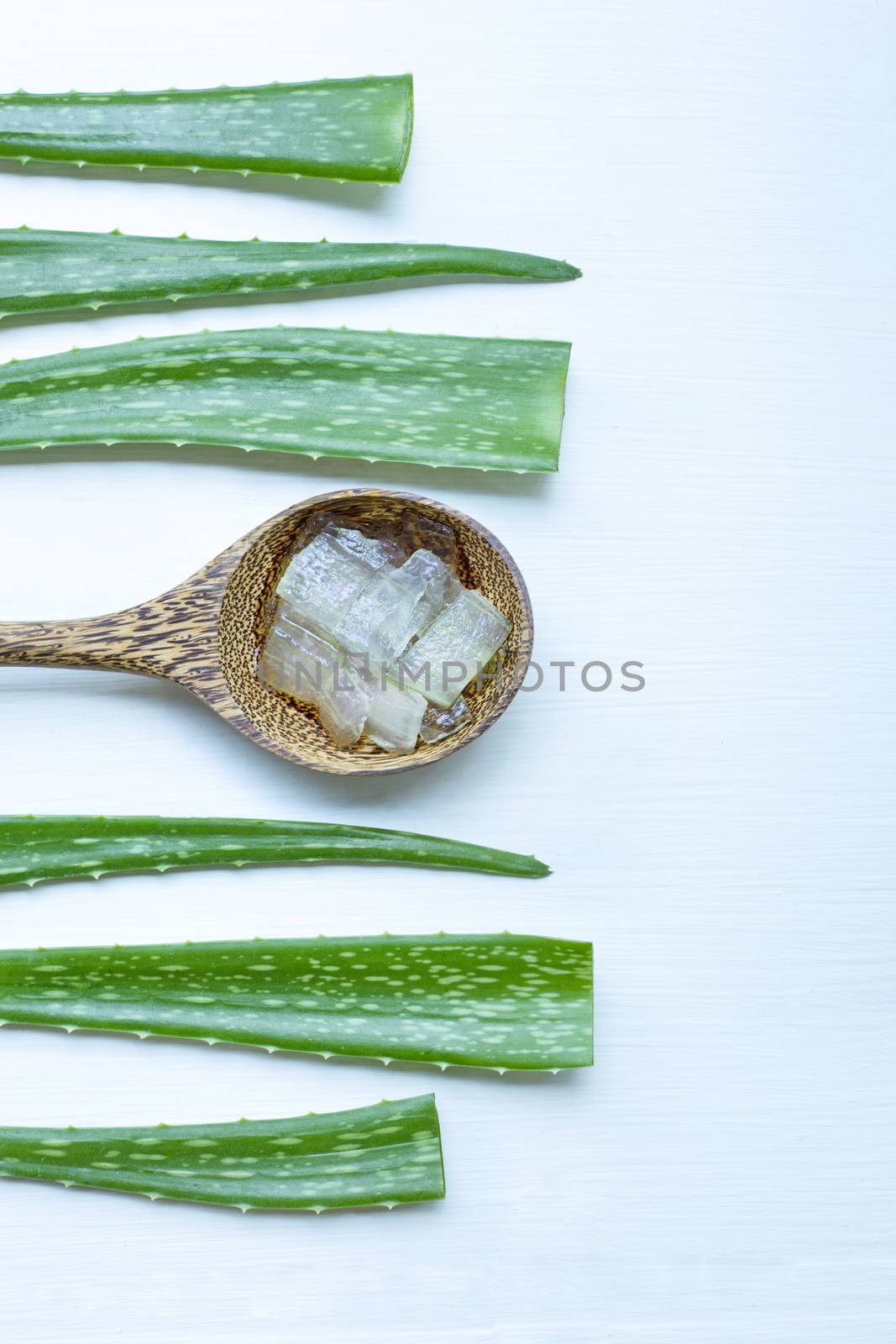 Aloe vera fresh leaves with aloe vera gel on wooden spoon. isolated white.