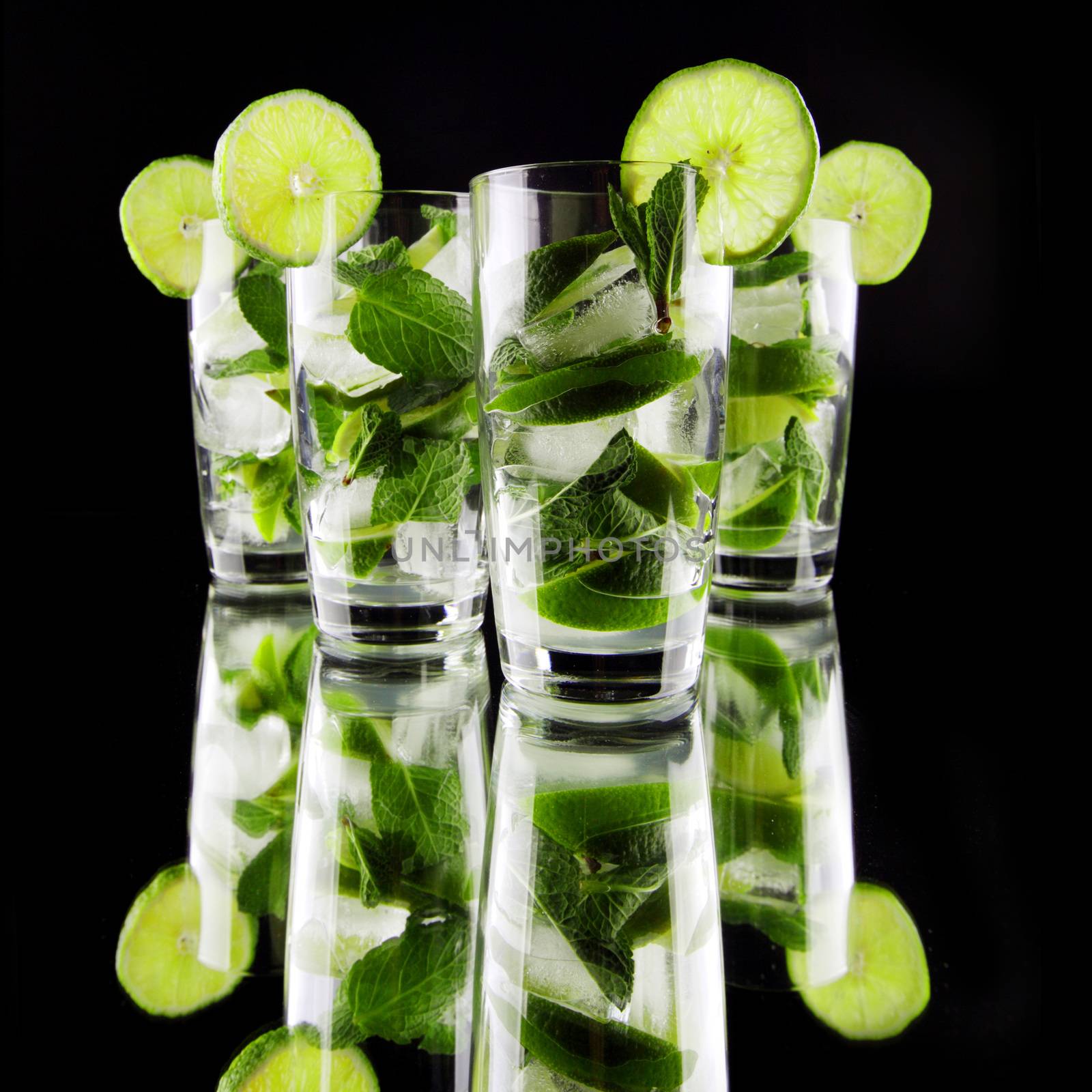 Mojito cocktails with lime and mint on black background 