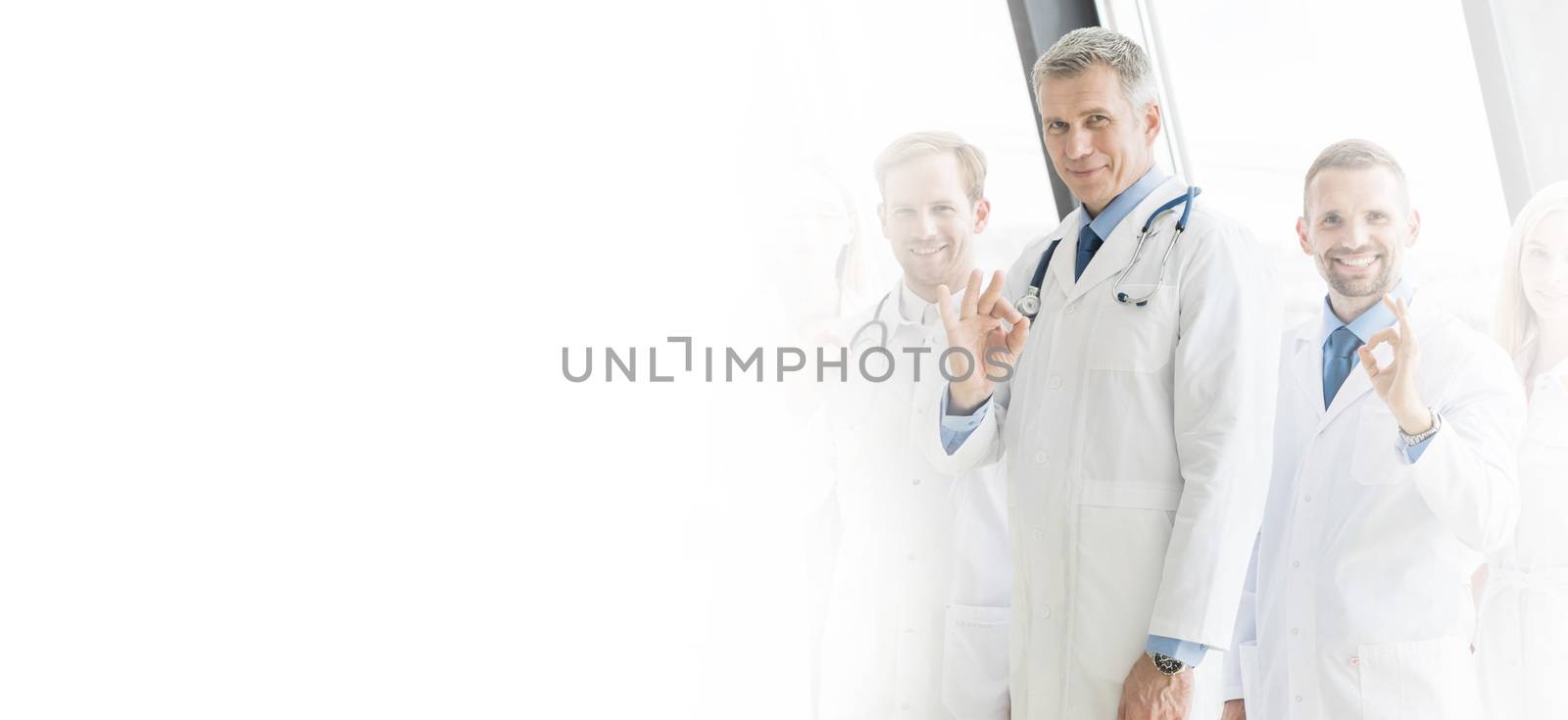 Medical team of doctors and in hospital showing ok sign