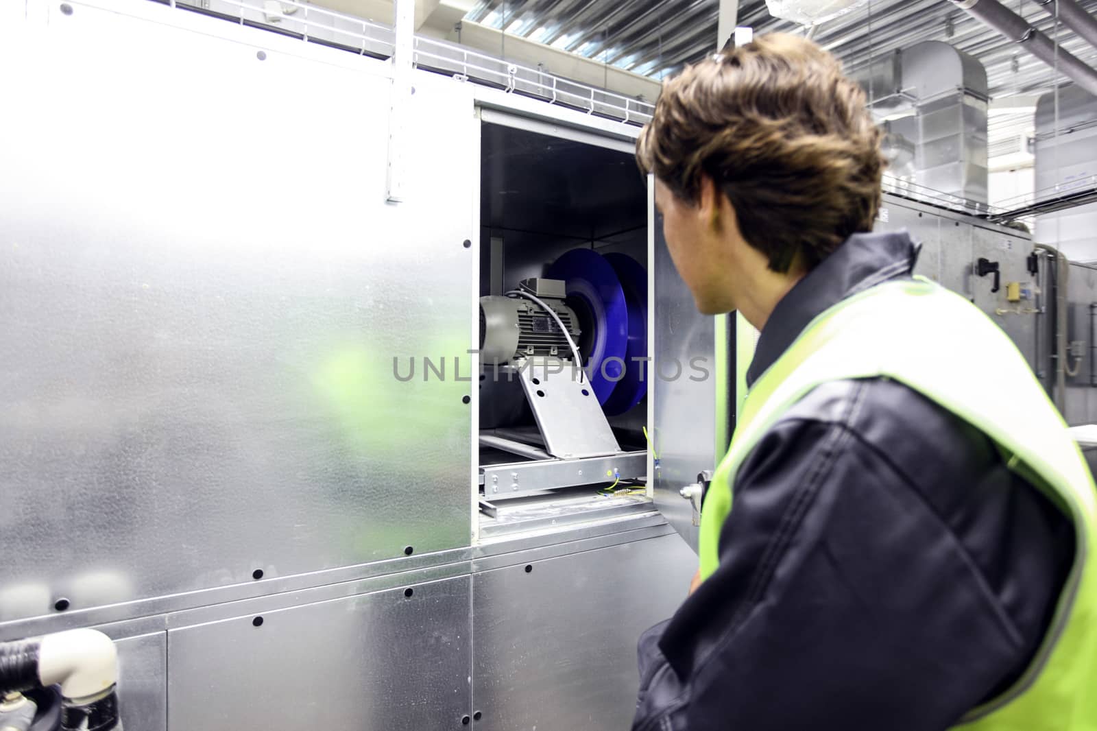 Worker in electrical switchgear room of CNC plant