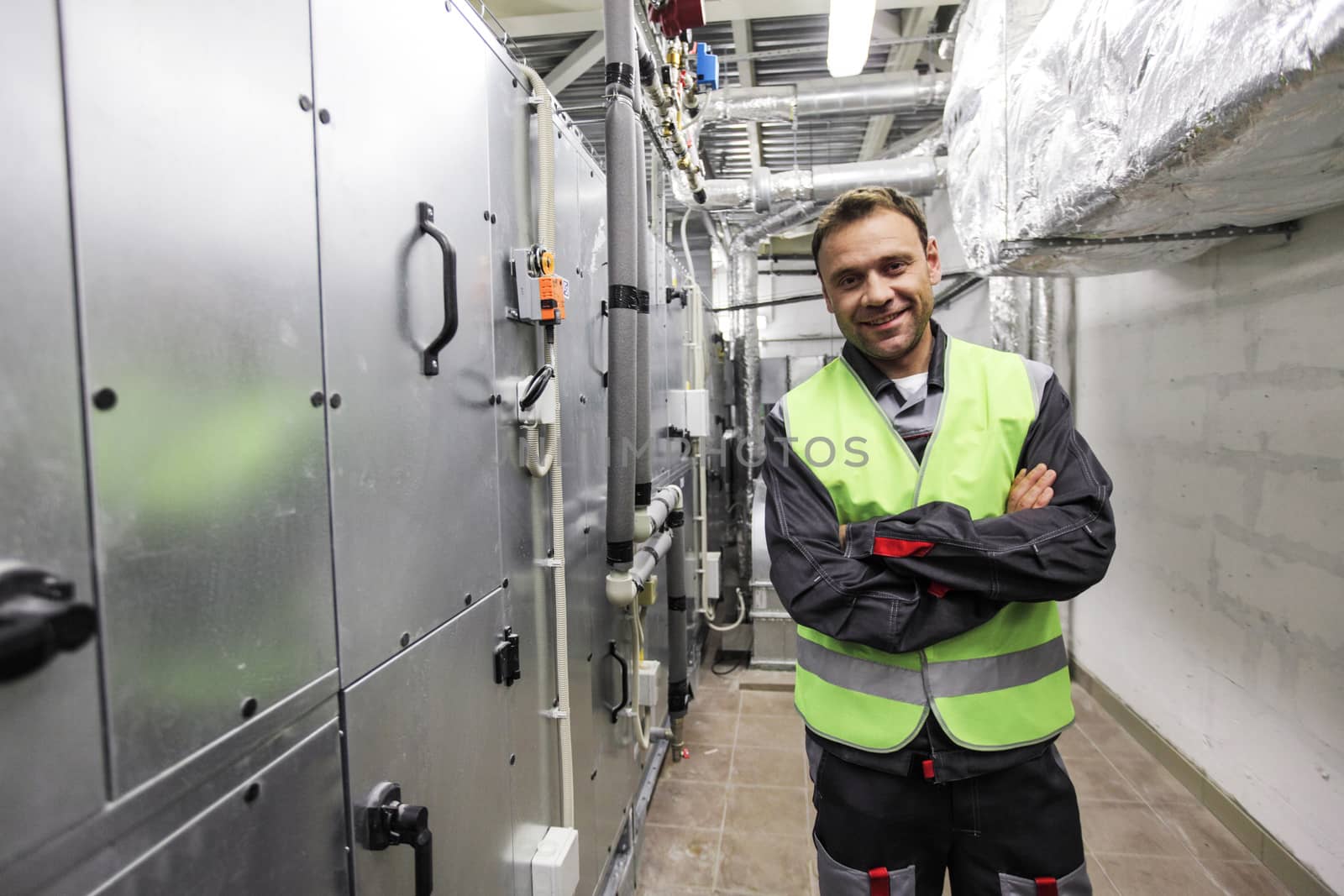 Portrait of smiling worker in electrical switchgear room of CNC plant