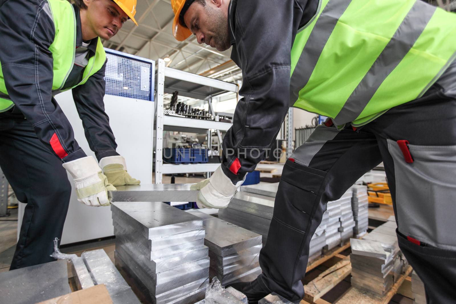 Workers taking aluminium billet at CNC machine shop