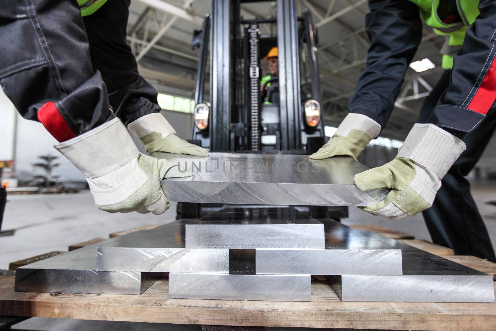 Workers taking aluminium billet at CNC machine shop