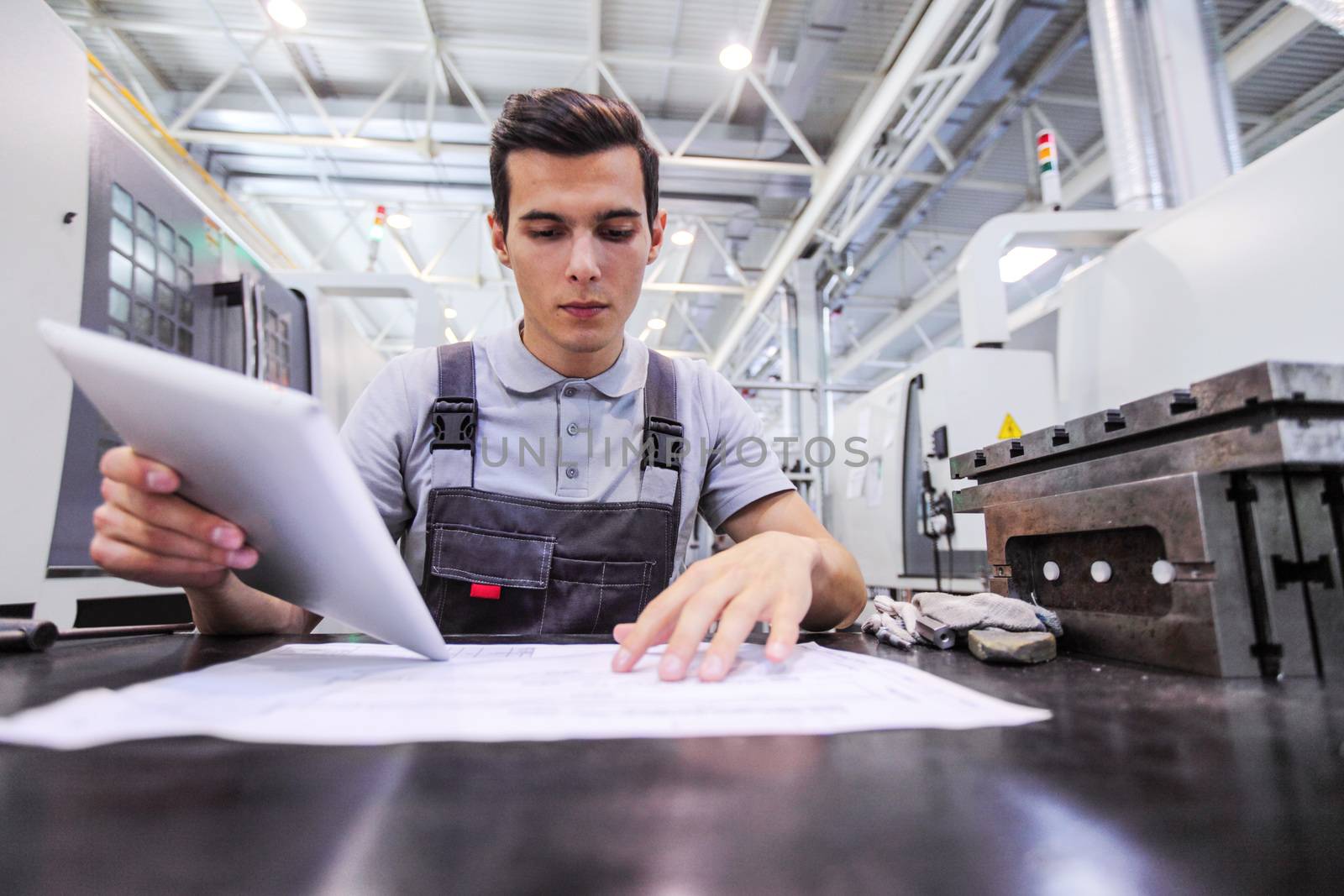 Man working with documents at plant near CNC machines