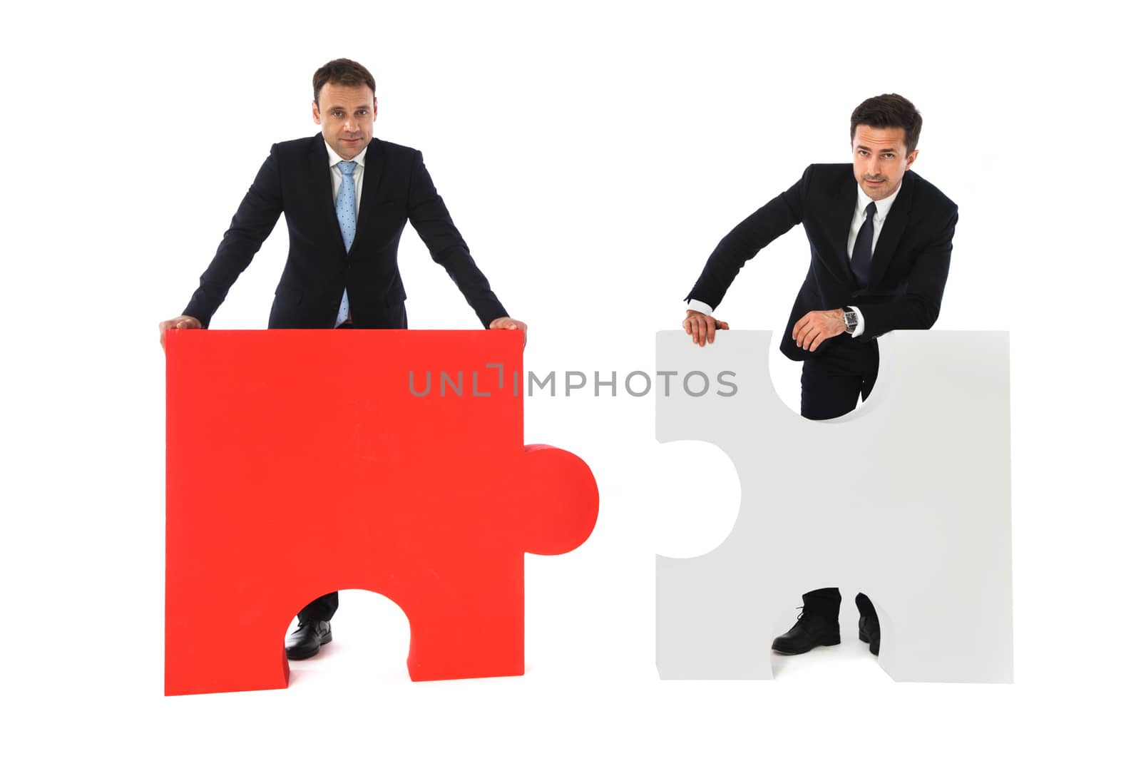 Business men holding two puzzles by ALotOfPeople