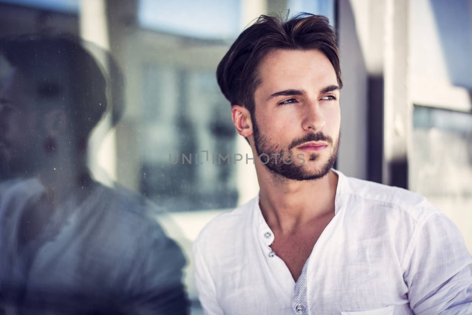 Stylish trendy young man standing outdoor against window by artofphoto